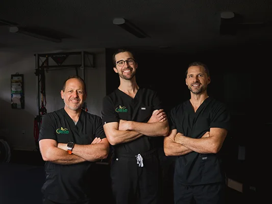 The doctors at GreenLife Wellness standing in the Physical Therapy room