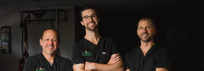The GreenLife Wellness doctors standing in the physical therapy room